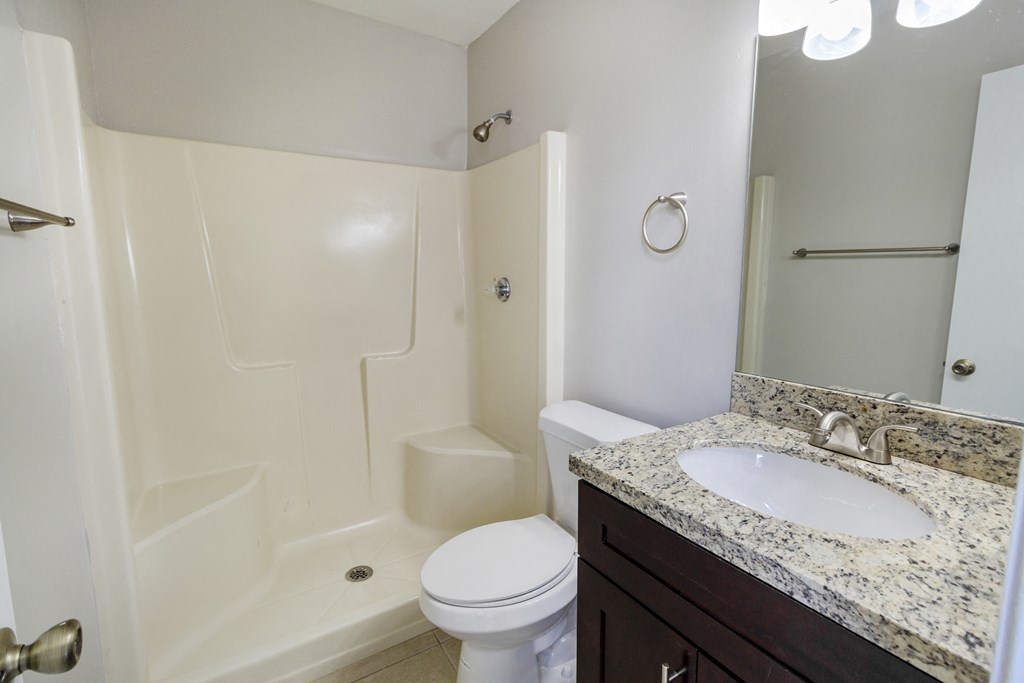 A white toilet sits next to a sink in a bathroom.